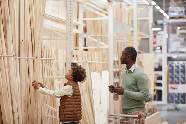 Adult and child looking at wood and lumber.