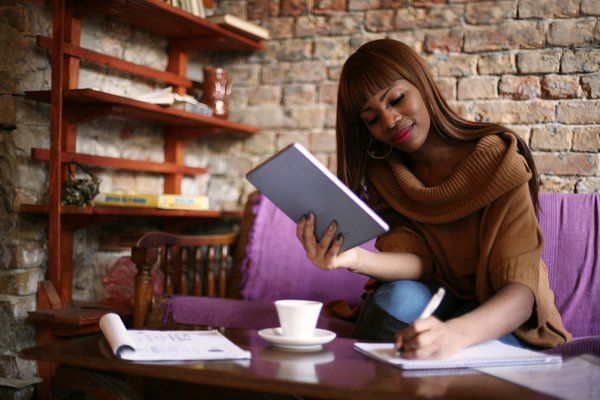 Young woman holding table calculating on notepad